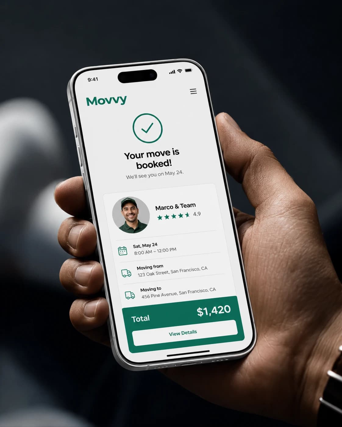 iPhone showing the Movvy booking confirmation screen with the crew lead Marco, their 4.9 star rating, the move date and time, pickup and drop-off addresses, and the total cost.